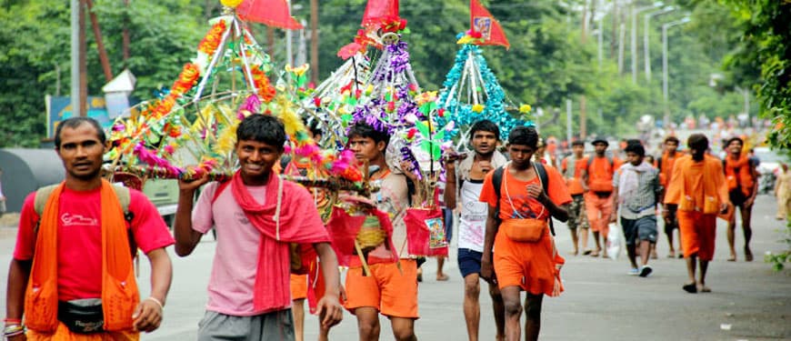 Kanwar Yatra pilgrims walking on highway from Delhi to Haridwar carrying kanwar on their shoulders
